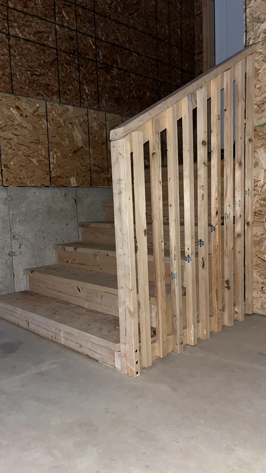 Basement stairs with a wood railing